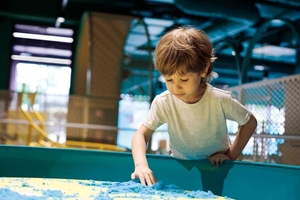 Γοητευτικό Αγοράκι Στο Κέντρο Παιδικού Παιχνιδιού Εξοικειώνεται Την Κινητική Άμμο — Φωτογραφία Αρχείου