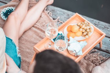 Nehir ya da göl kenarında piknik yapan, kadın ve erkek birlikte şarap içen, yaz tatilinde eğlenen, duyguları seven genç ve tanınmayan çiftin en iyi görüntüsü.