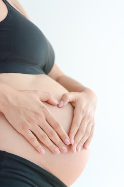 Hamile kadın karnına dokunuyor.