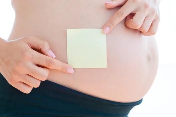 Pregnant woman with blank yellow sticker — Stock Photo, Image