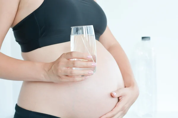 Pregnant woman holding glass of water — Stock Photo, Image