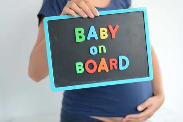 Zwangere vrouw bedrijf blackboard Rechtenvrije Stockafbeeldingen