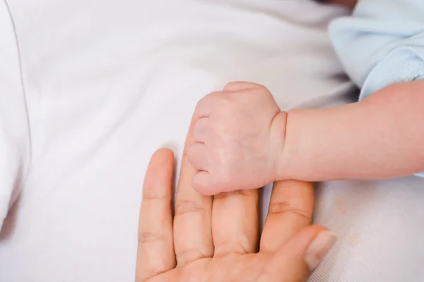 Baby holding finger of mother — Stock Photo, Image