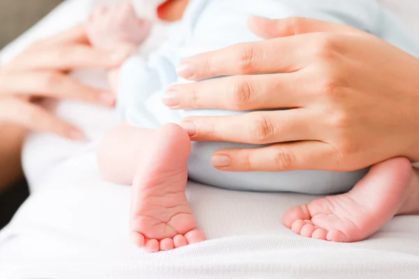 Female hands and cute feet of newborn — Stock Photo, Image