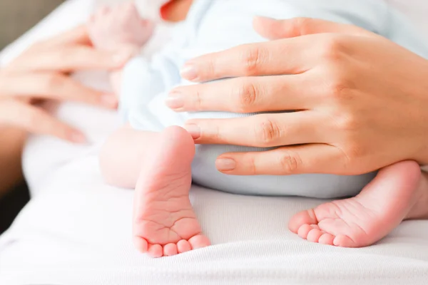 Mains féminines et pieds mignons de nouveau-né — Photo