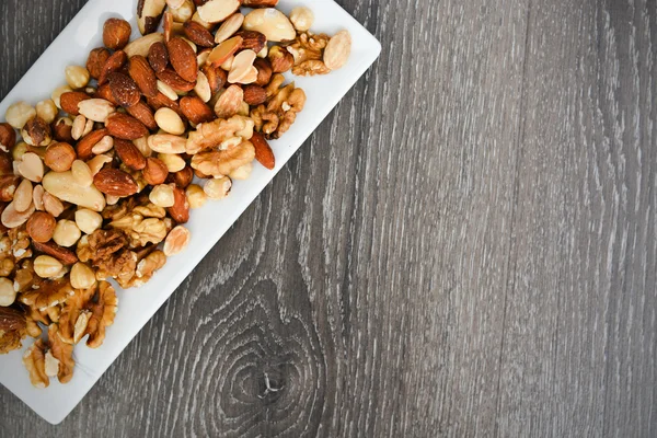 Pile of nuts on white plate — Stock Photo, Image