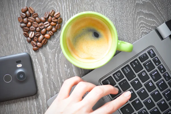 coffee cup with laptop and heart of beans