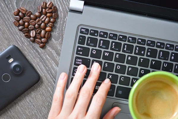 Taza de café con portátil y corazón de frijoles —  Fotos de Stock