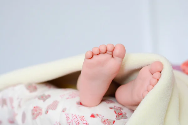 Baby fötter lutar av filt — Stockfoto