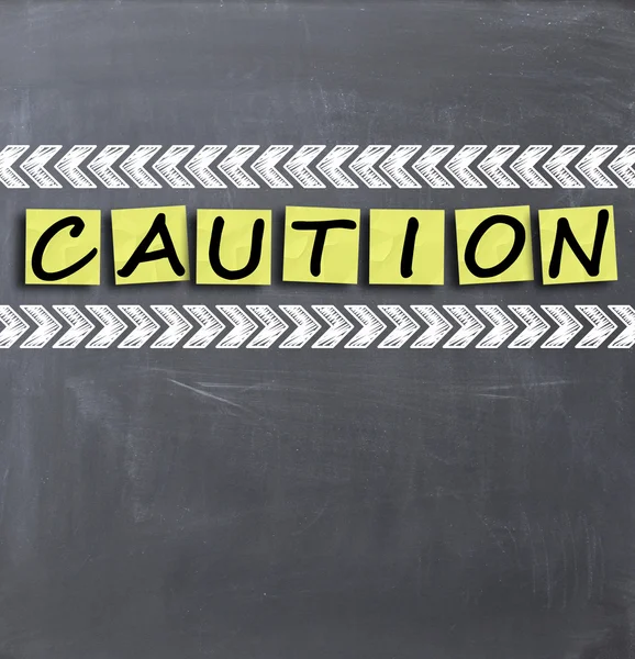 Caution text on blackboard — Stock Photo, Image