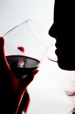 Kadın kırmızı şarap içiyor.