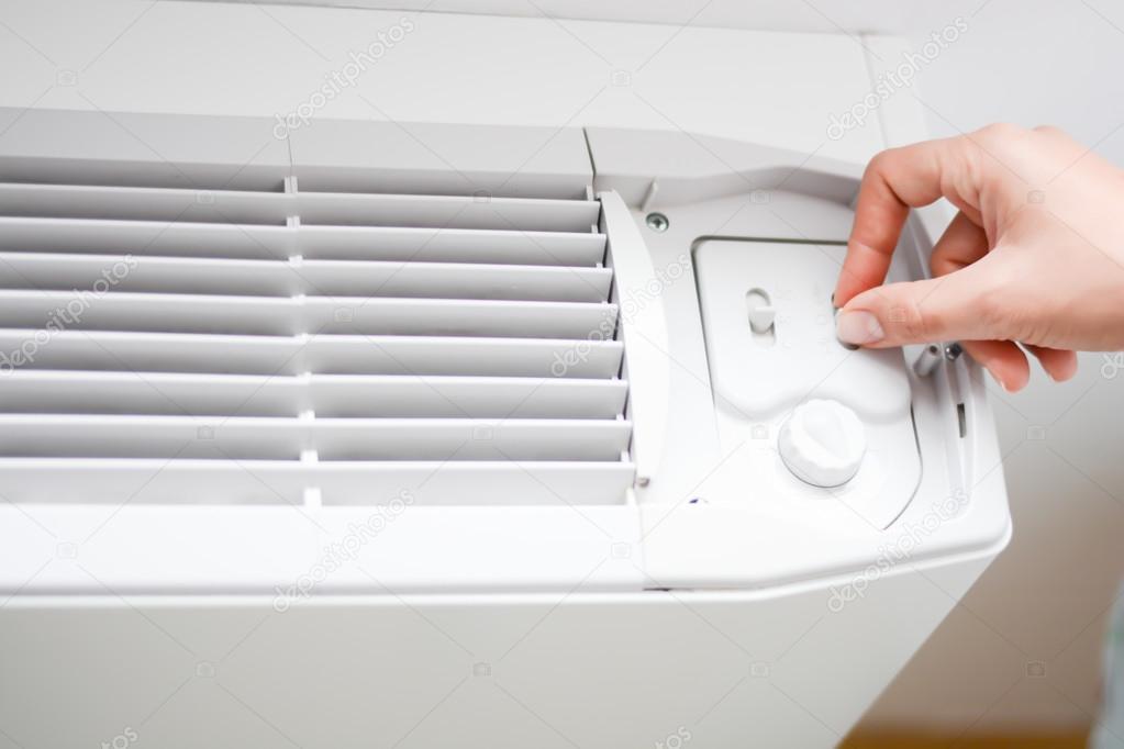 Female hand adjusts radiator