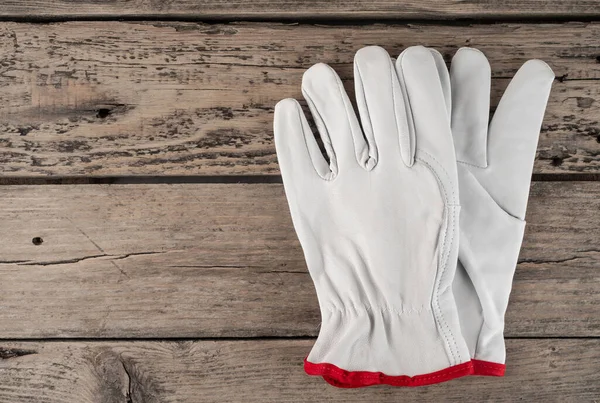 gray leather gloves for work. work gloves on a wooden background