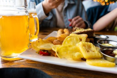 Barda taze bira. Bira atıştırmalıkları. Bira için cips ve soğan halkaları.