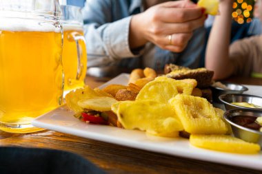 Barda taze bira. Bira atıştırmalıkları. Bira için cips ve soğan halkaları.