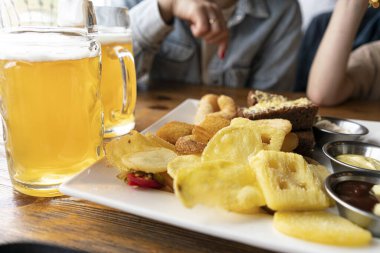 Barda taze bira. Bira atıştırmalıkları. Bira için cips ve soğan halkaları.