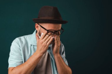 Maskeli adam yorgun hissediyor. Erkeklerde baş ağrısı. Maskeli bir adam migrenden muzdarip. Uzun bir çalışmadan sonra yorgunluk