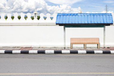 yol tarafında ve otobüs bekleyen beyaz büyük duvar.