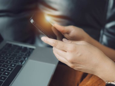 Akıllı telefon kullanan bir kadın, rahat bir evde oturan genç bir hippi kız ve modern akıllı telefon cihazı kullanan, elinde siyah bir dokunmatik telefon tutan bir kadın. Sosyal ağ oluşturma kavramı.