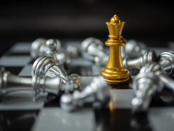 Satranç. Strateji fikirleri Planlama ve Karar konsepti işi. Altın kraliçesi satrancın etrafını birkaç gümüş satranç taşı sarmış. İş stratejisi kavramı.