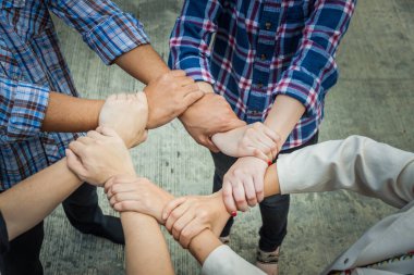 Takım çalışması konsepti. İş adamları el ele tutuşuyor. Takım çalışması konsepti, iş ekibinin çatı katında el ele tutuşması. İşbirliğine katılan insanlar, başarı işi, her şeyde kazanmak, klasik renk.