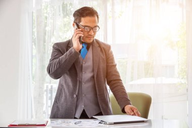 İş adamı telefon ve laboratuarla çalışır, iş adamı ofiste akıllı telefon kullanır..