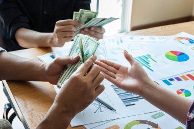 Başarılı iş adamlarından oluşan bir ekip Amerikan dolarını elinde tutuyor, olumlu duygu.,