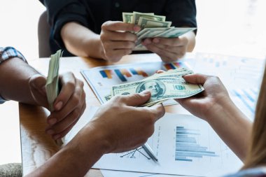 Başarılı iş adamlarından oluşan bir ekip Amerikan dolarını elinde tutuyor, olumlu duygu.,