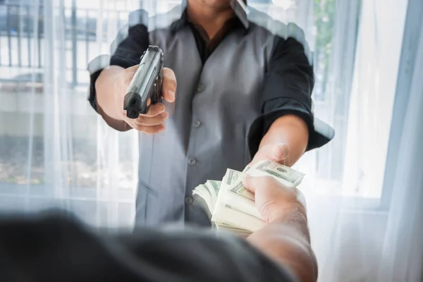 Bir sürü parası ve silahı olan bir gangster, takım elbiseli sakallı bir erkek, havada para banknotu, elinde silah ve viskiyle Asyalı bir mafya üyesi, güvenli evdeki masada oturuyor.