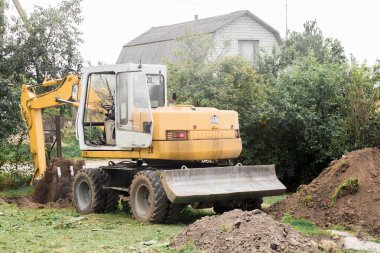 Bir buldozer sanayi bölgesinde açık havada kazı yapıyor. Kazı. Belarus, Minsk Bölgesi - 13 Ağustos 2020.