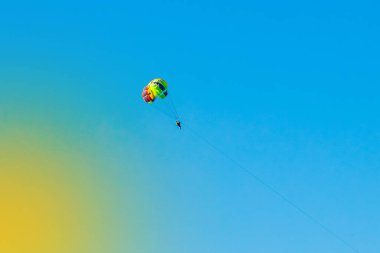 Bir erkek ve bir kadın turist mavi gökyüzüne paraşütle atlıyorlar. Aşırı tatil konsepti.