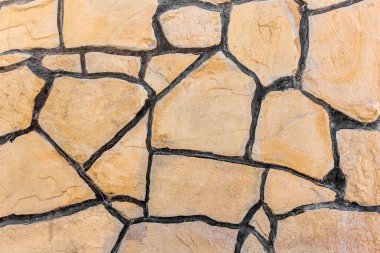 Soyut desenli taş duvar, siyah boya dokusu ön plan.