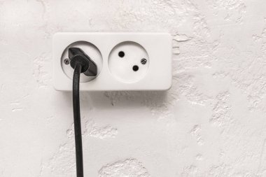 Beyaz alçı üzerine siyah prizli çift prizli modern duvar arka planı.