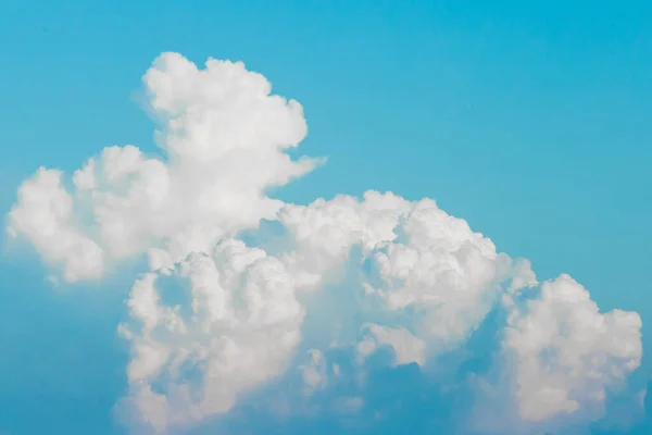 Large white cumulus clouds texture on blue sky background.