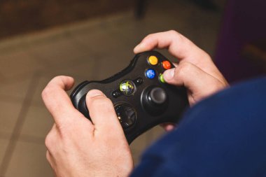 Belarus, Minsk Bölgesi - 27 Ağustos 2017: Adamın elleri bir joystick xbox tutuyor ve bir konsol oynuyor, yakın plan.