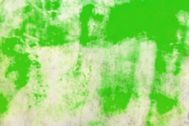 Soyut duvar arka planında yeşil boya lekeleri ve desenleri var..