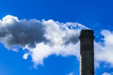 Çevre kirliliği, çevre sorunu, endüstriyel bir fabrikanın borusundan çıkan duman veya mavi gökyüzüne karşı termik enerji santrali.