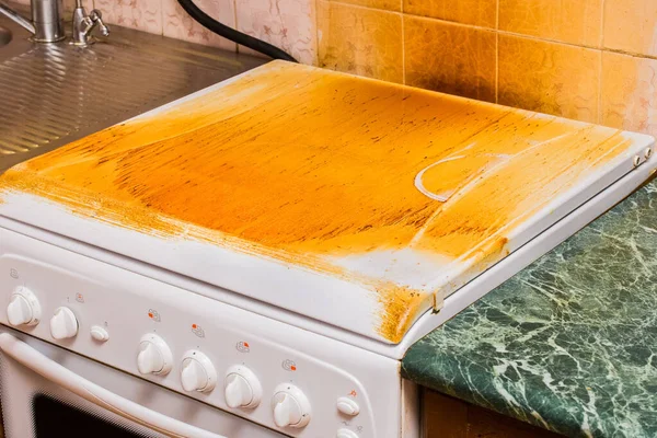 Gaz sobasında kirli yapışkan kaplama. Mutfakta ev temizliği..
