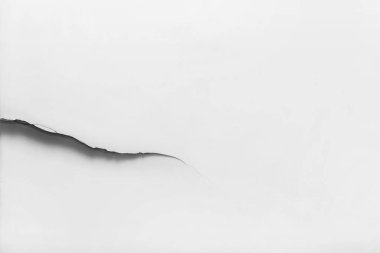 Beyaz hasarlı duvarda büyük bir çatlak, kırık ışık arkaplanı, kopyalama alanı, yakın plan..