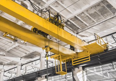 Endüstriyel bir atölyenin arka planındaki bir inşaat malzemesi vincinin parçası..