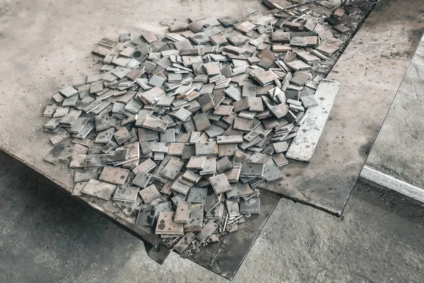 Metal waste, embedded parts for concrete structures with reinforcement, iron plates, industrial waste at the construction site.