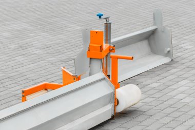 Sert yüzeyleri kaldırım taşından döşeme levhalarının arka planıyla dengelemek için kullanılan endüstriyel ekipmanların bir parçası. İnce kum, kum ve çeşitli substratları siler.