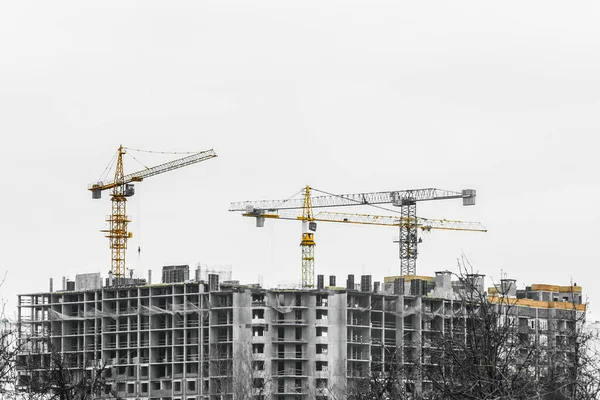 Construction tower industrial cranes on site. Building design, development and work in the creation of urban architecture.