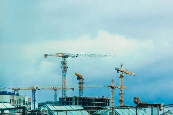 Construction tower industrial cranes on site. Building design, development and work in the creation of urban architecture.