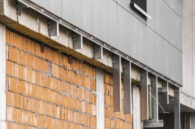 Yeni bir modern tamamlanmamış binanın ön cephe onarım tuğlası duvarı, yüksek katlı şehir binası yeniden yapılandırması.