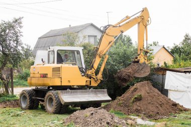 Bir buldozer sanayi bölgesinde açık havada kazı yapıyor. Kazı. Belarus, Minsk Bölgesi - 13 Ağustos 2020.