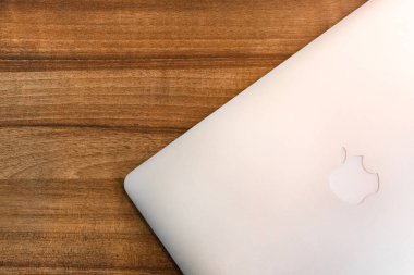 Belarus, Minsk bölgesi - 17 Mart 2020: Ahşap masa arkaplanındaki Apple dizüstü bilgisayarı.