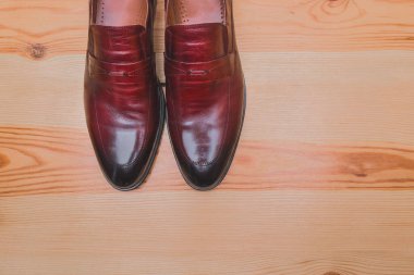 Erkek ayakkabıları, ahşap zemin üzerinde kırmızı kahverengi deri stanttan yapılmış fotokopi alanı.