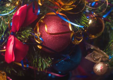 Süslü Noel ağacında parıltılı ve kurdeleli kırmızı yılbaşı balosu, yakın plan..