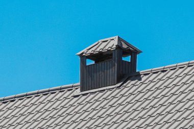 Evin modern çelik çatısının metal demir yapıları mavi gökyüzüne karşıdır..